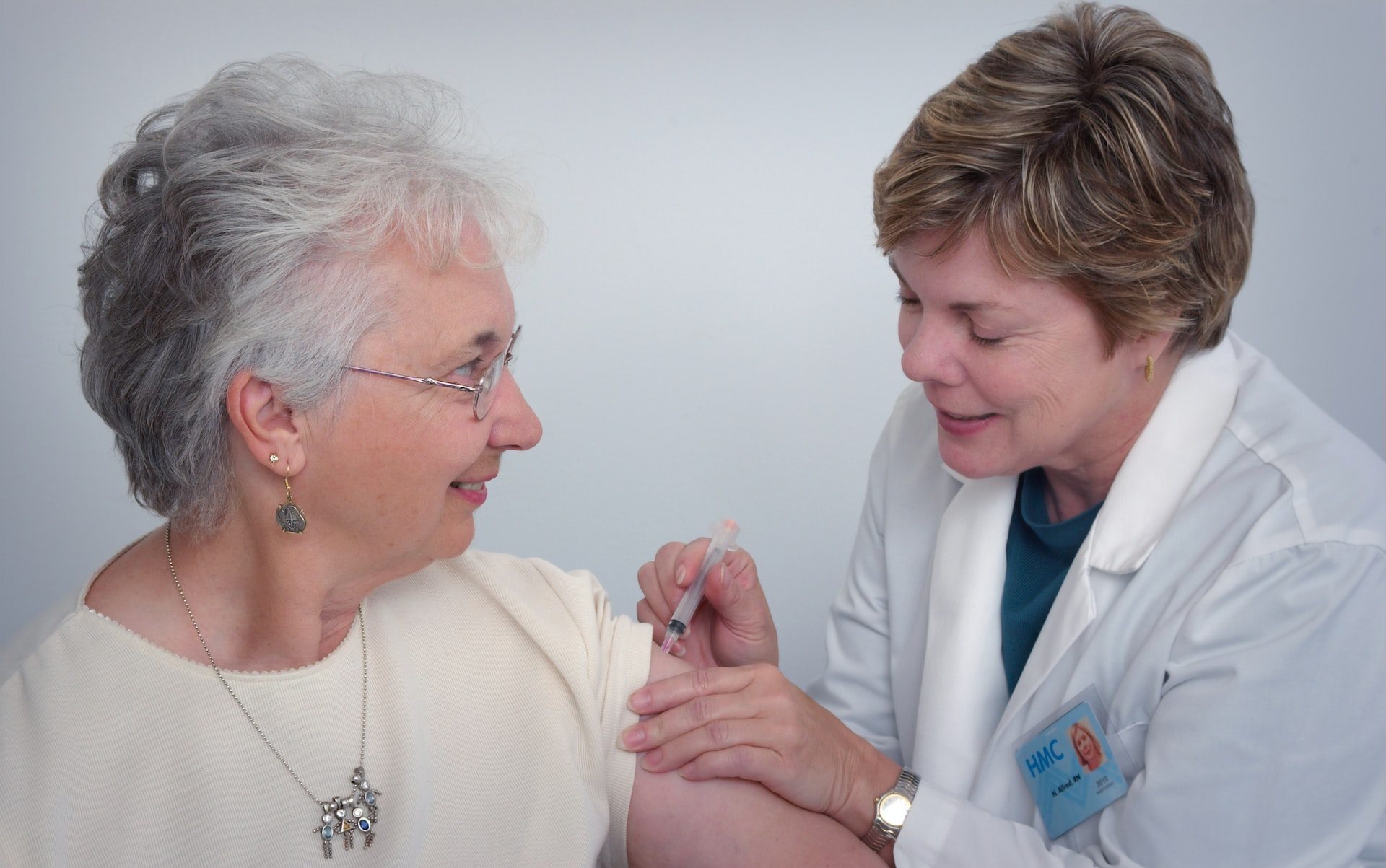 woman inject a woman on left shoulder